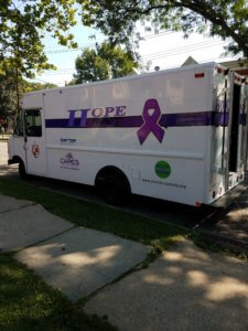 Hope One vehicle with purple ribbon parked on street