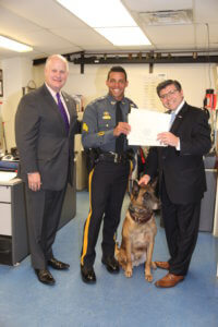 Assemblyman Bucco presents the citation to Sheriff Gannon, an officer, and a K-9 dog