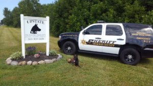 New Sheriff's Office K9 in front of agency vehicle and Upstate K9 sign.