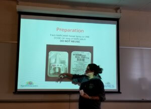 CARES Peer Recovery Specialist Carrie Bailey walks CCM students through the steps of using Narcan to revive a person overdosing on opioids.