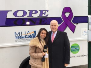 Morris County Sheriff James M. Gannon and WJLP-TV Journalist Kimberly Kravitz standing in front of Hope One mobile substance abuse recovery vehicle 