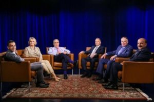 Members of The Stoler Report on set, sitting in chairs