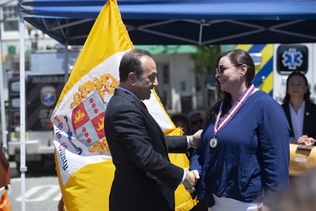 Susan Foelsch-Maher shakes Commissioner Selen's hand after receiving her medal.