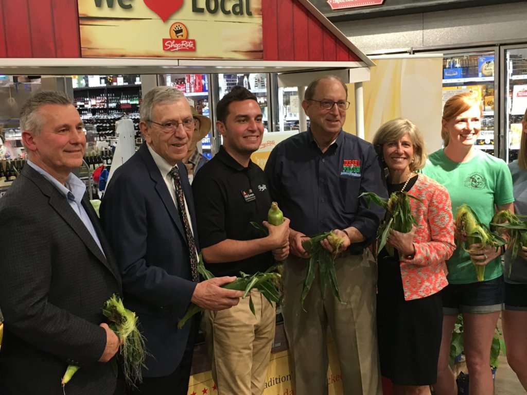 photo of Ids for the first photo, left to right: Joe Kurtz, director of Produce, Floral and Bakery for Village Super Market, Inc.; Bob Sumas, president, Village Super Market, Inc.; Will Sumas, Village Super Market, Inc.; Douglas H. Fisher, New Jersey Secretary of Agriculture; Christine Myers, Morris County Freeholder; Erin Freeborn, Tranquillity Farms each holding an ear of corn in the produce aisle, 