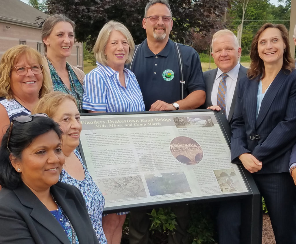 photo shows officials at the new Mt. Olive historial marker attown hall. (l/r) County Assistant Engineer Roslyn Khurdan, Mount Olive Historian Thea Dunkle, Freeholder Kathy DeFillippo, County heritage Commission Acting Director Peg Shultz, Freeholder Deborah Smith, Mayor Rob Greenbaum, Freeholders Doug Cabana and Heather Darling