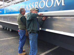 photo of workmen getting the floating classroom ready for the water