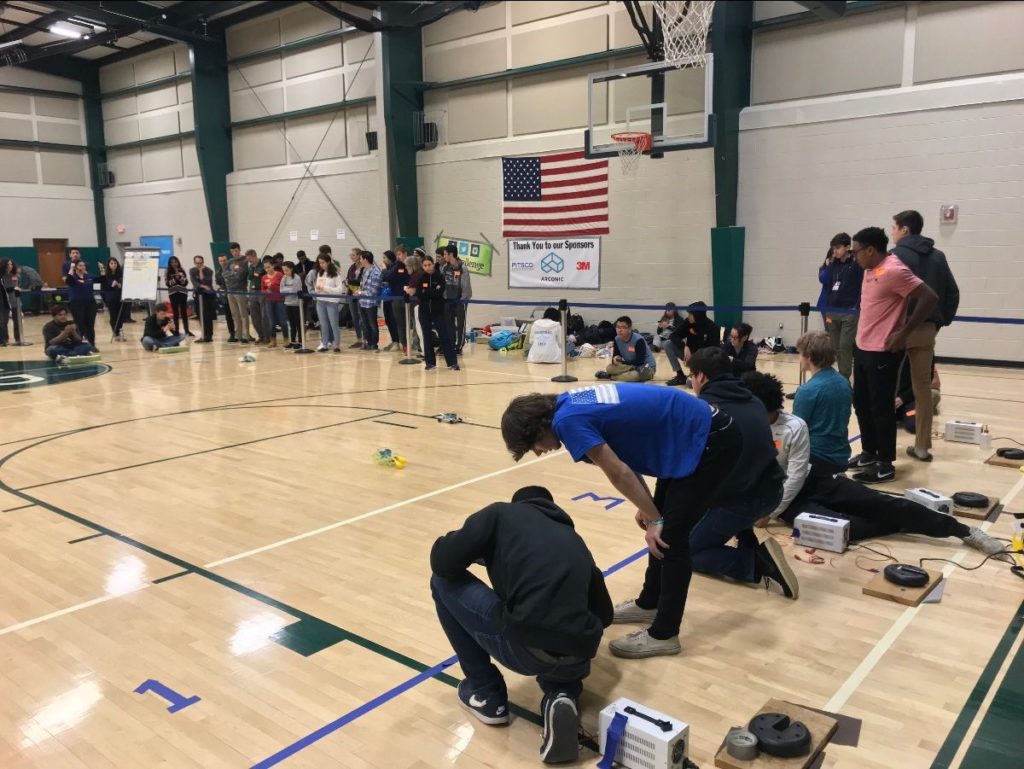 photo shows students working on their H2 Challenge vehicles in the school gym 