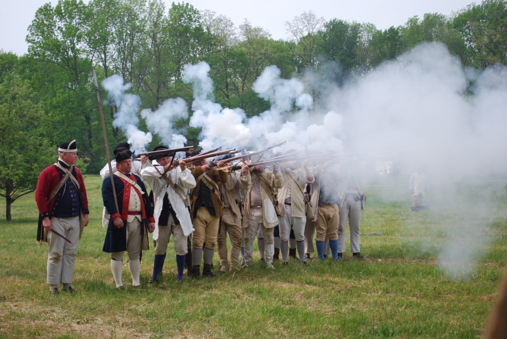 photo of Revolutionary War Reenactors firing weapons