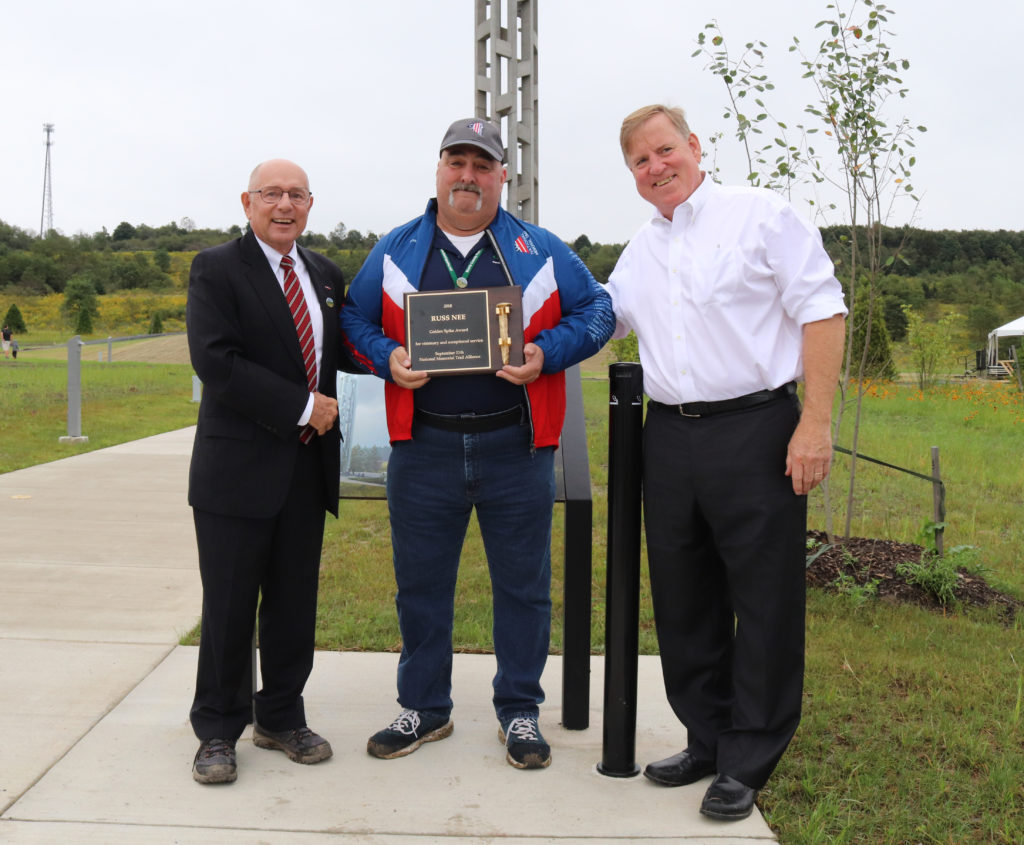 Photo: Russ Nee (c) of Randolph, accepts the distinguished Golden Spike Award in Shanksville, PA from 9 Memorial Trail Alliance President Emeritus, David G. Brickley (L), of Woodbridge, Virginia, and Chairman of the Board of Director, Andy Hamilton (R) of Bucks County, PA.