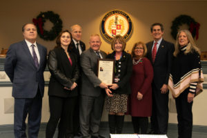 Susan Calantone poses , holding her resolution, with the entire freeholder board