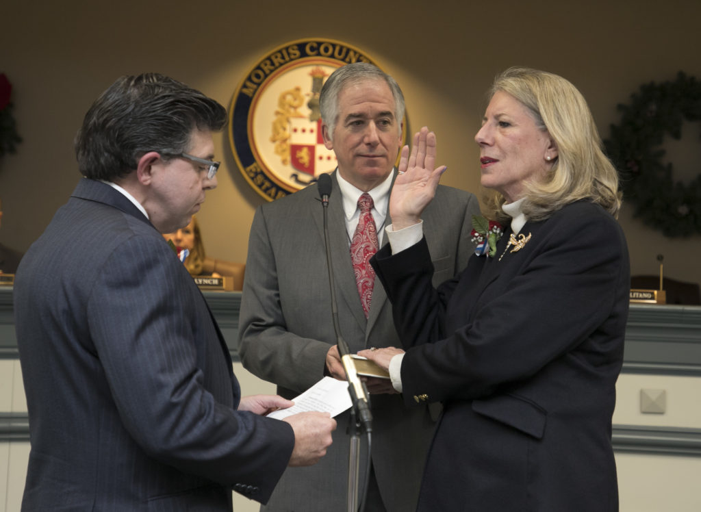 Deborah Smith takes oath of office from Assemblyman Anthony Bucco, as her husband looks on