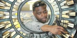 Photo shows a man working at an advanced manufacturing work station