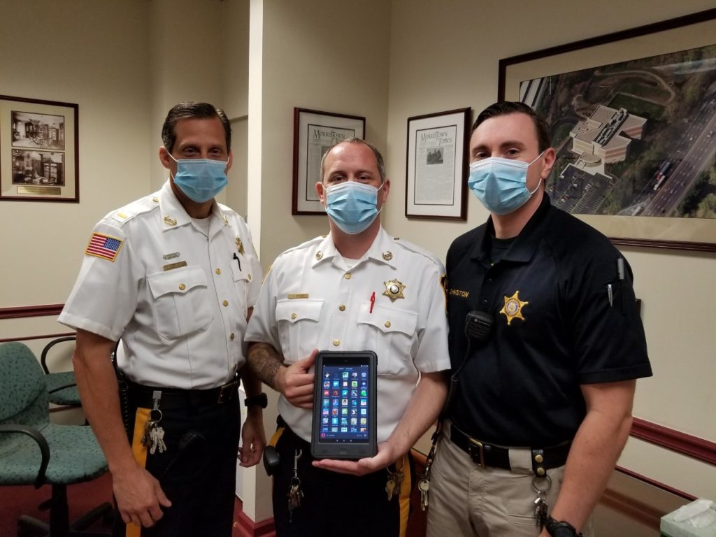 Corrections Lt. Michael Schweizer, Sgt. Raymond Dykstra and Sgt. Shawn Johnston with a tablet.