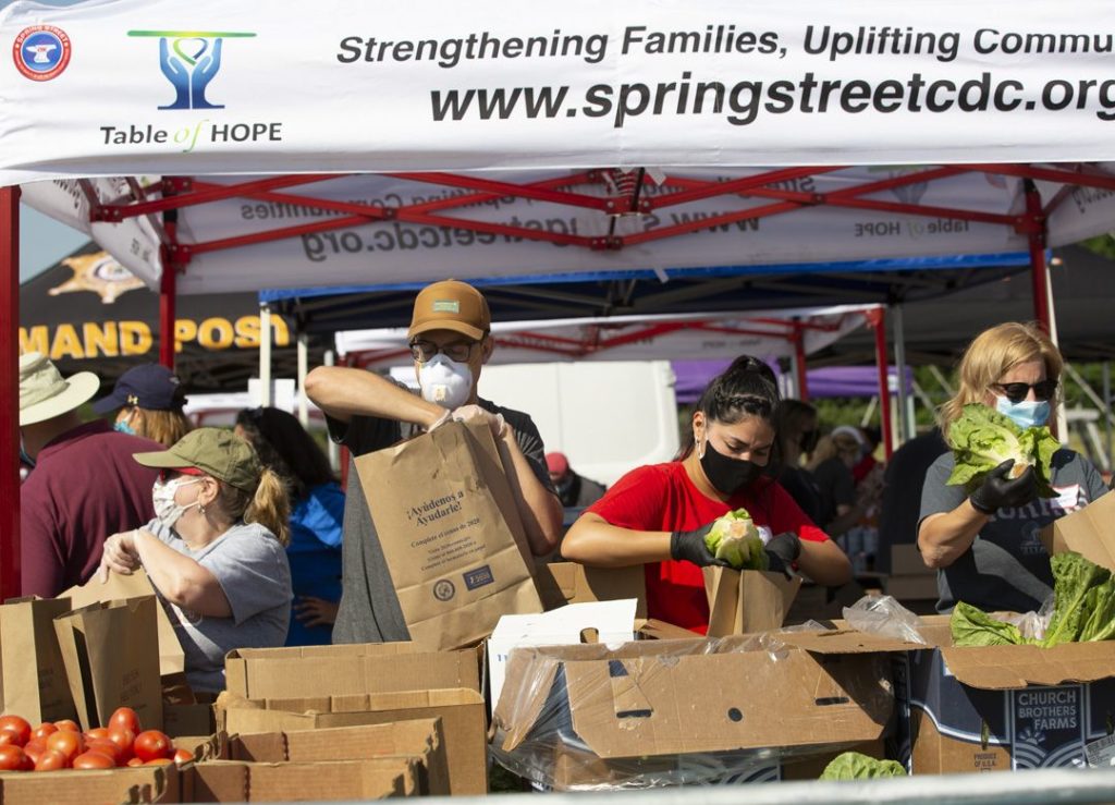 photo shows volunteers packaging food at June distriution event by Table of Hope 