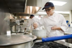 culinary student stirs a pot